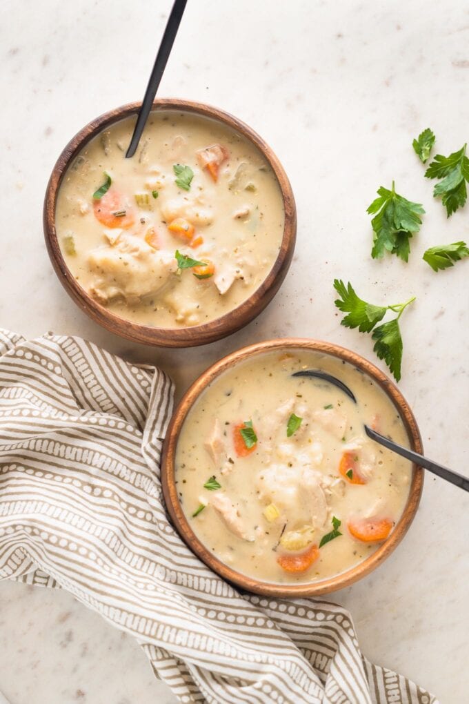 Two bowls of creamy turkey and dumplings soup.