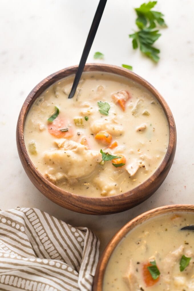 Bowl of creamy turkey and dumplings soup with a spoon, ready to eat.