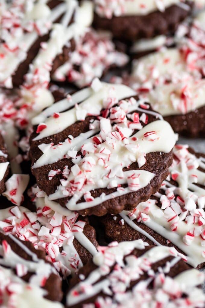 Close up of a peppermint bark cookie, drizzled in white chocolate and sprinkled with crushed peppermints or candy canes.