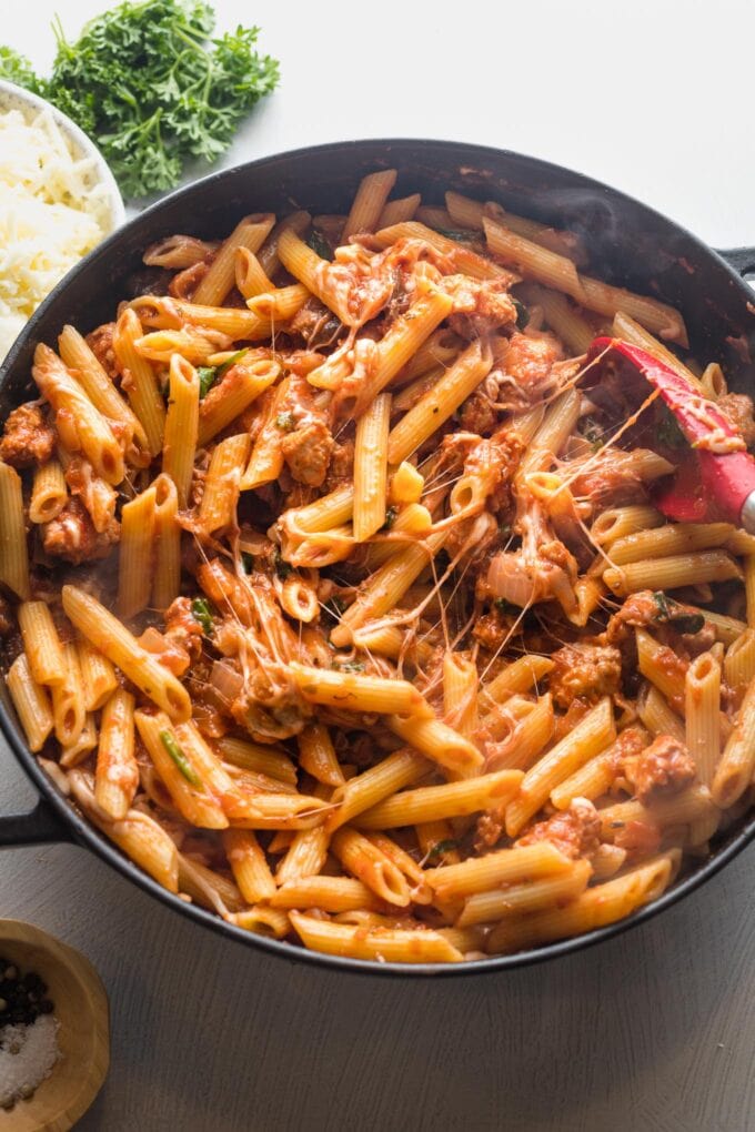 Cheese melted into pasta with tomato sauce.