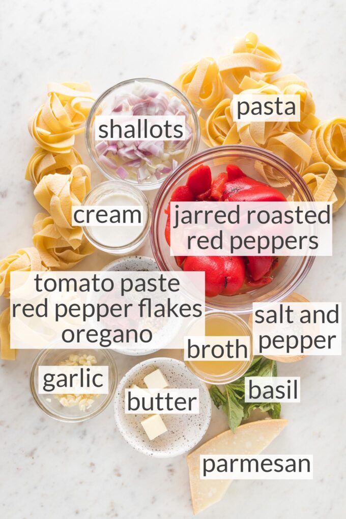 Prep bowls containing pasta, shallots, cream, jarred roasted red peppers, tomato paste, red pepper flakes, oregano, garlic, butter, salt, pepper, basil, and Parmesan.