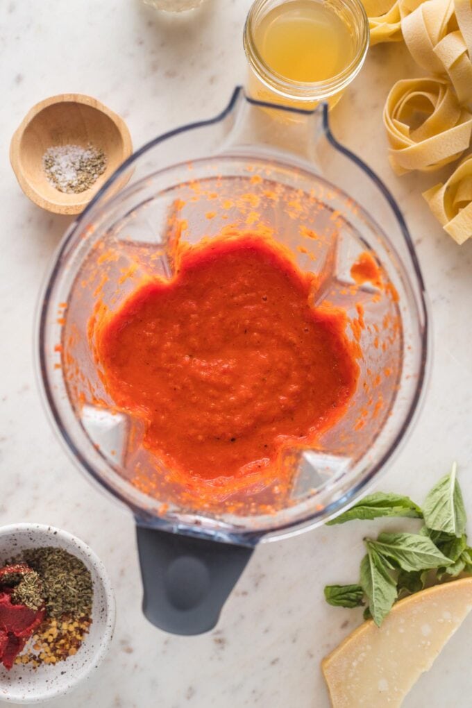 Red pepper mixture blitzed into a smooth sauce in a blender.