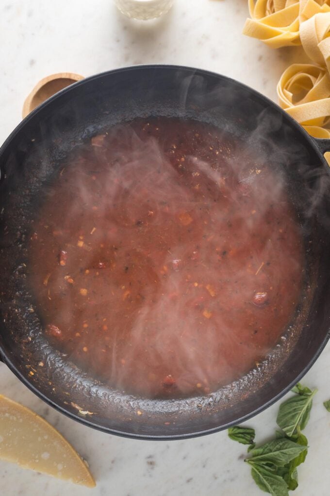 Broth, tomato paste, and seasonings hot in the skillet.