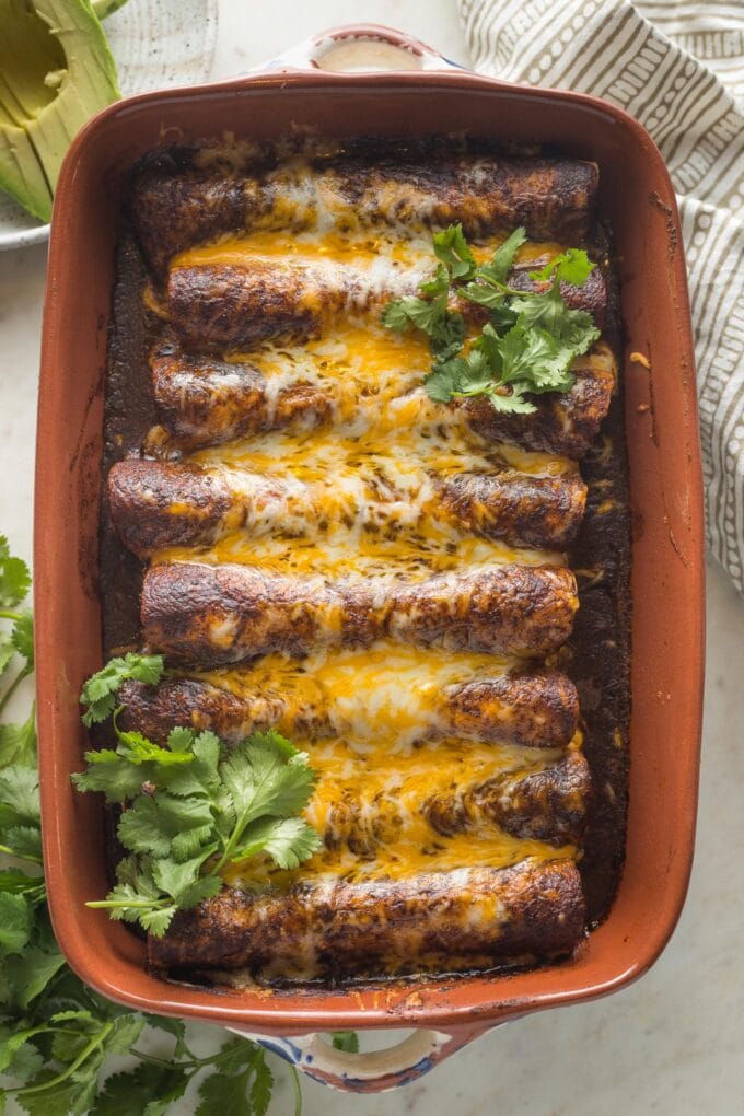 Baking dish filled with black bean enchiladas with corn.