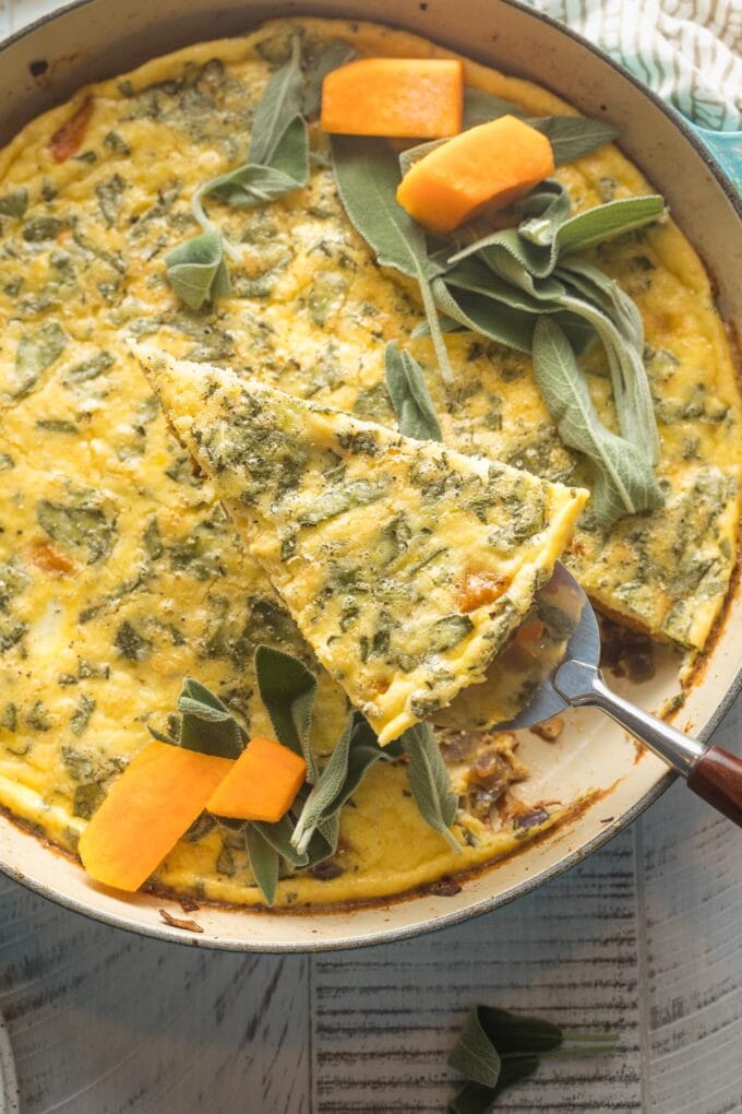 Close-up of a slice of frittata being lifted out of the skillet.