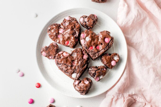 White plate with finished heart shaped brownies in two sizes.