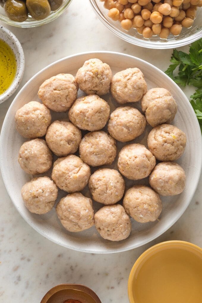 Shaped chicken meatballs, ready to be browned and then baked.