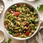 White bowl full of chicken pesto pasta salad.