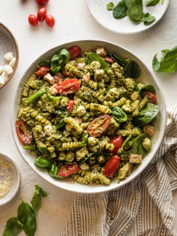 White bowl full of chicken pesto pasta salad.