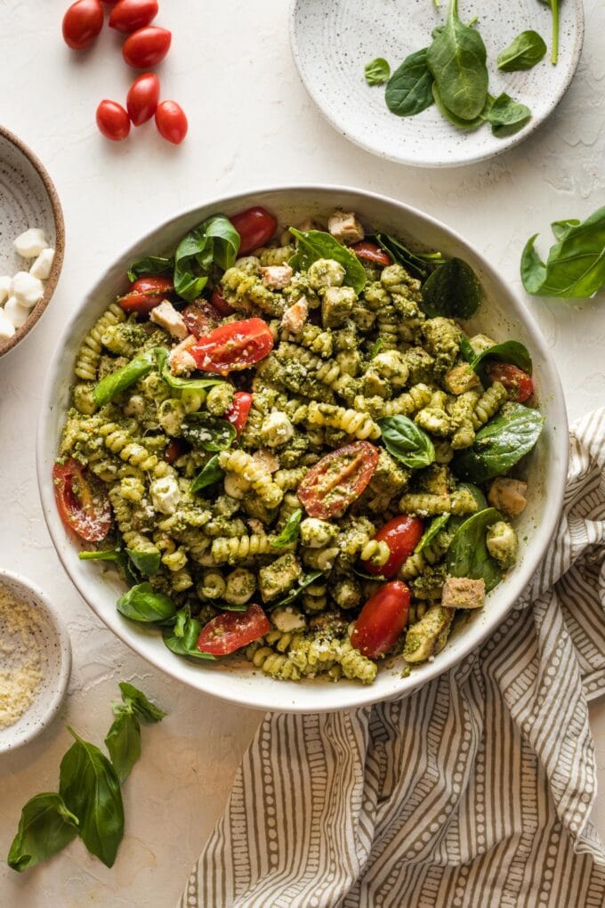 White bowl full of chicken pesto pasta salad.