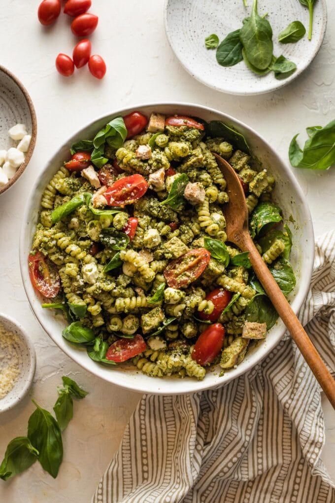 White bowl full of chicken pesto pasta salad.