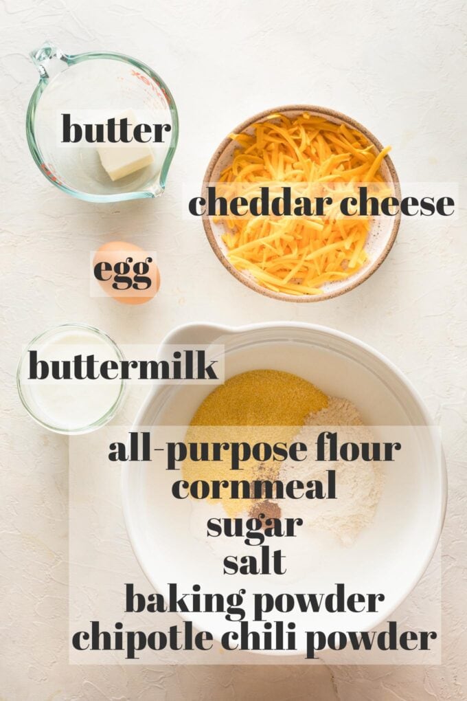 Labeled photo of prep bowls holding butter, cheddar cheese, one egg, buttermilk, all purpose flour, cornmeal, sugar, salt, baking powder, and chipotle chili powder.