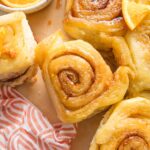Close up of an orange sweet roll with cinnamon-sugar filling and an orange glaze effect instead of icing.