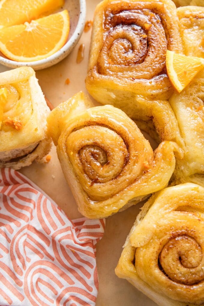 Close up of an orange sweet roll with cinnamon-sugar filling and an orange glaze effect instead of icing.