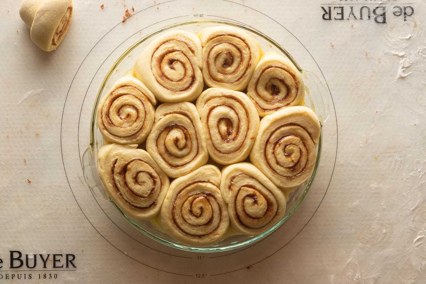 Puffy orange rolls filling the pie plate and ready to bake.