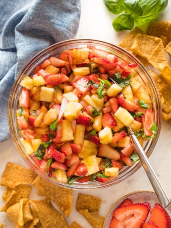 Serving bowl filled with sweet balsamic strawberry pineapple salsa, served with cinnamon churro chips.