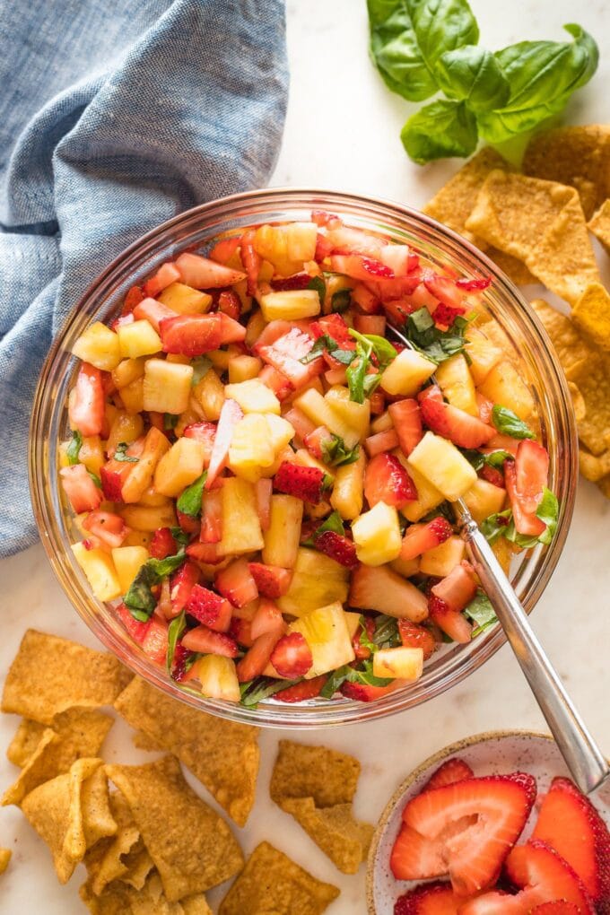 Serving bowl filled with sweet balsamic strawberry pineapple salsa, served with cinnamon churro chips.