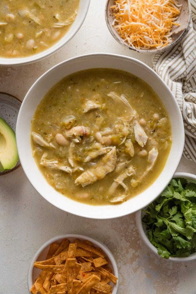 Bowl of white bean chicken chili with green chiles and salsa verde, no toppings yet so you can see the moderately thick consistency.
