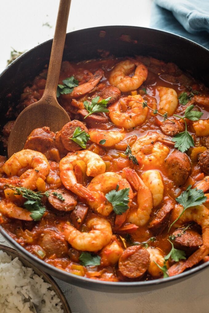 Close up of a serving spoon lifting a portion of jambalaya.