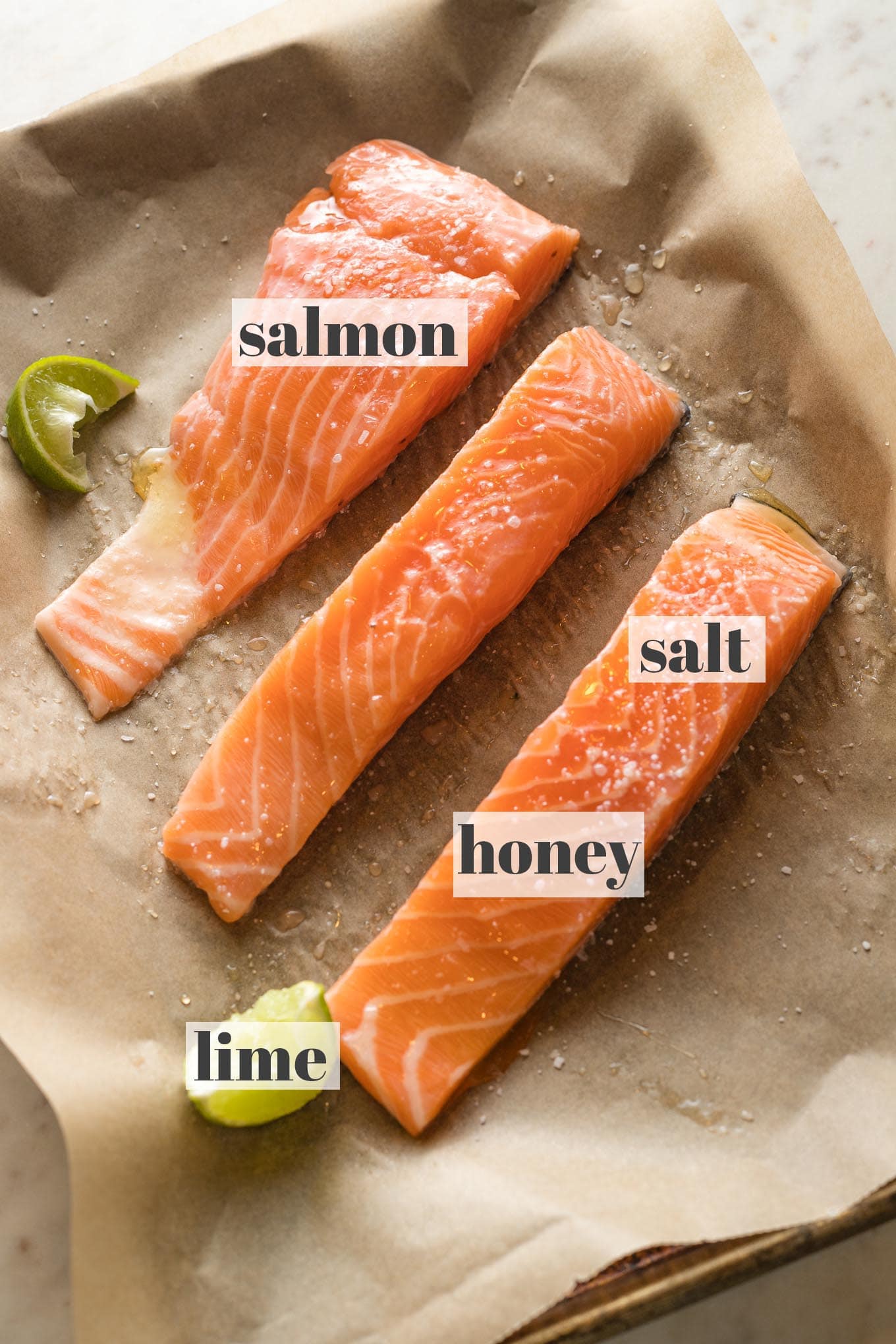 Labeled photo of salmon filets brushed with honey and sprinkled with lime juice and salt.