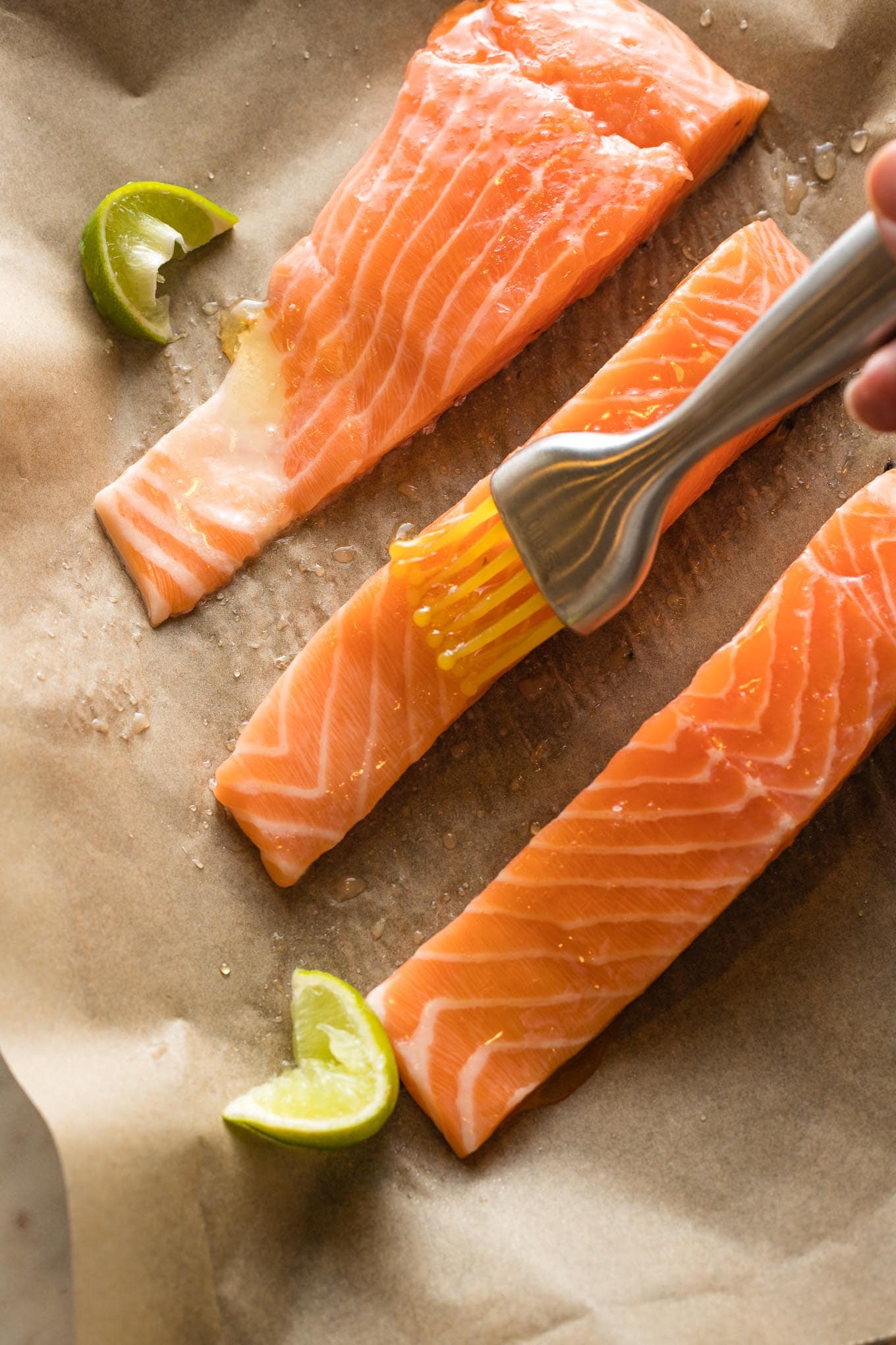 Brushing honey on salmon with a pastry brush.