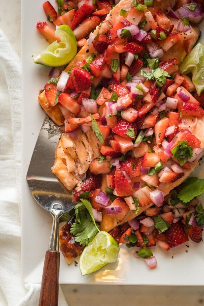 Close up of flaky salmon topped with strawberry salsa.