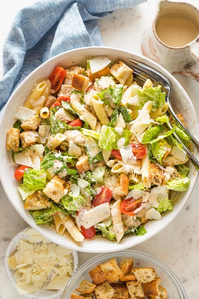 Large serving bowl filled with chicken Caesar pasta salad.