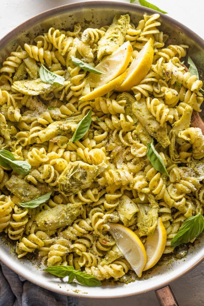 Close up of pasta with artichoke hearts, pesto, and lemon.
