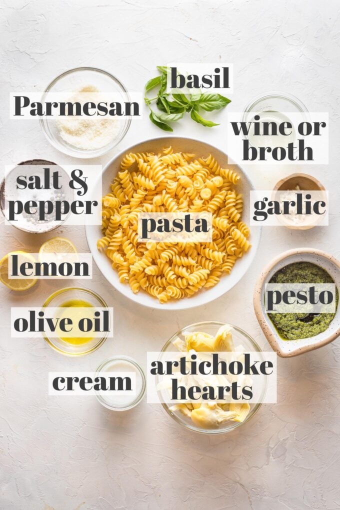 Prep bowls filled with ingredients for pasta with artichoke hearts: rotini, white wine, garlic, basil, Parmesan, pesto, lemon, cream, olive oil, artichoke hearts, and lemon.