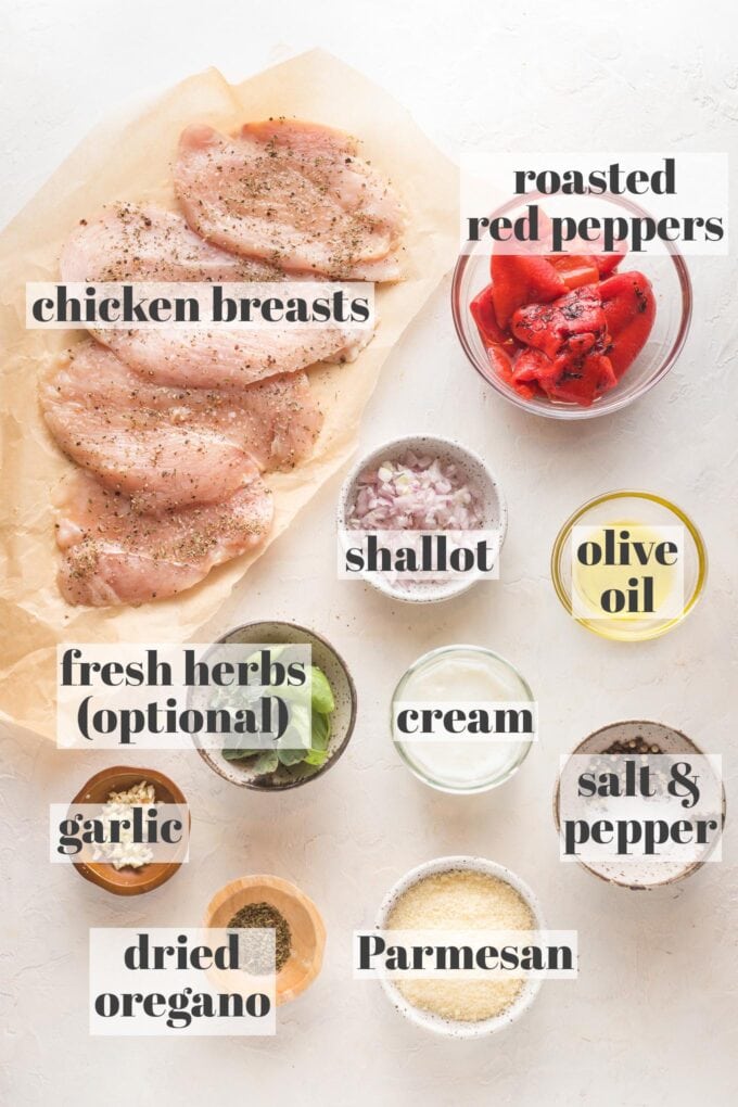 Prep bowls with chicken breasts, roasted red peppers, chopped shallot, olive oil, cream, fresh herbs, salt and pepper, garlic, dried oregano, and Parmesan.