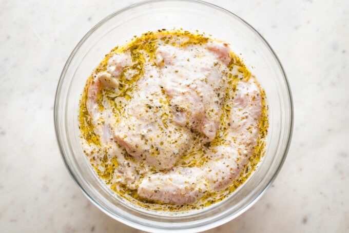 Chicken breasts nestled in a yogurt-based Greek marinade.