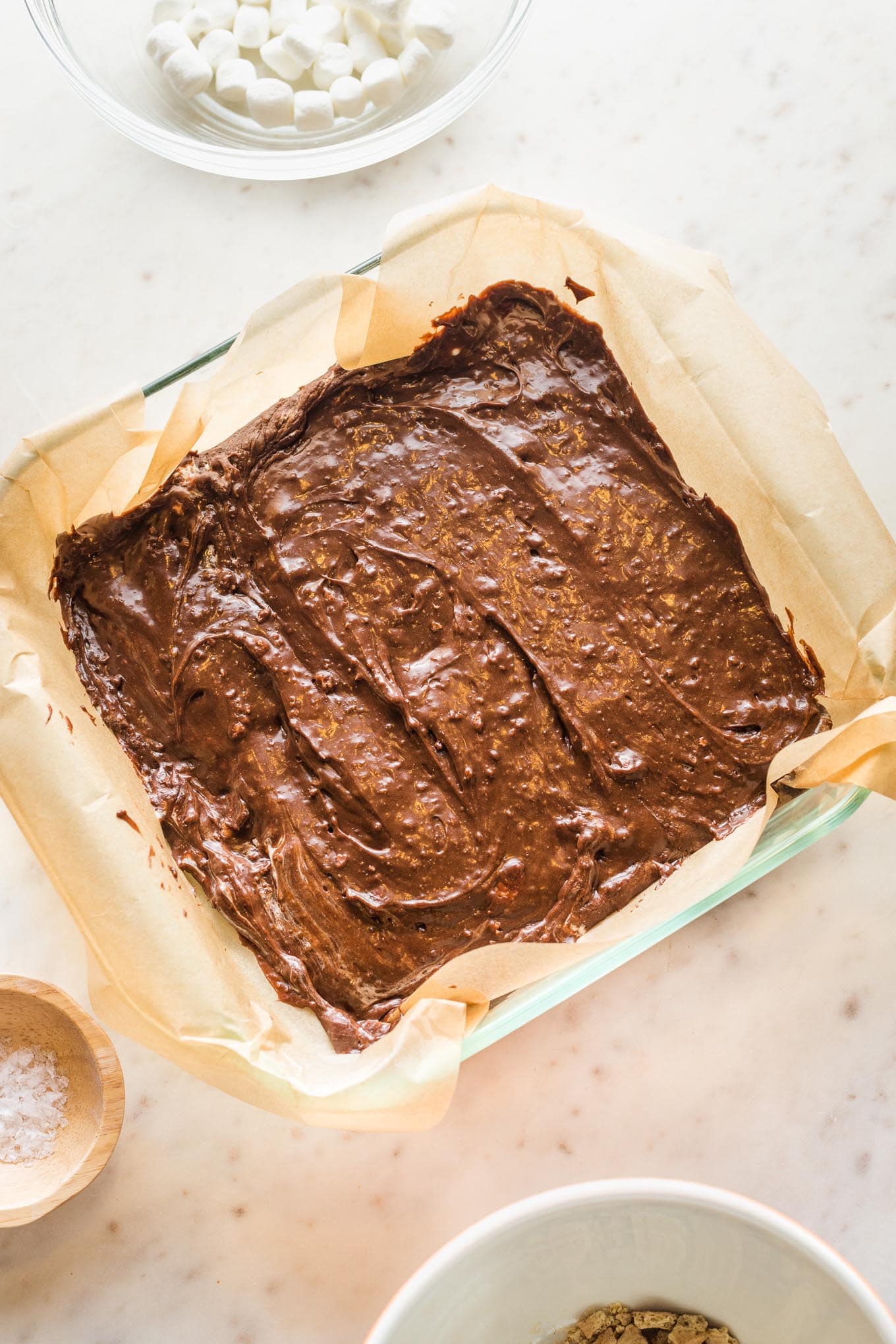 S'mores fudge base spread into a parchment-lined 8"x8" baking pan.