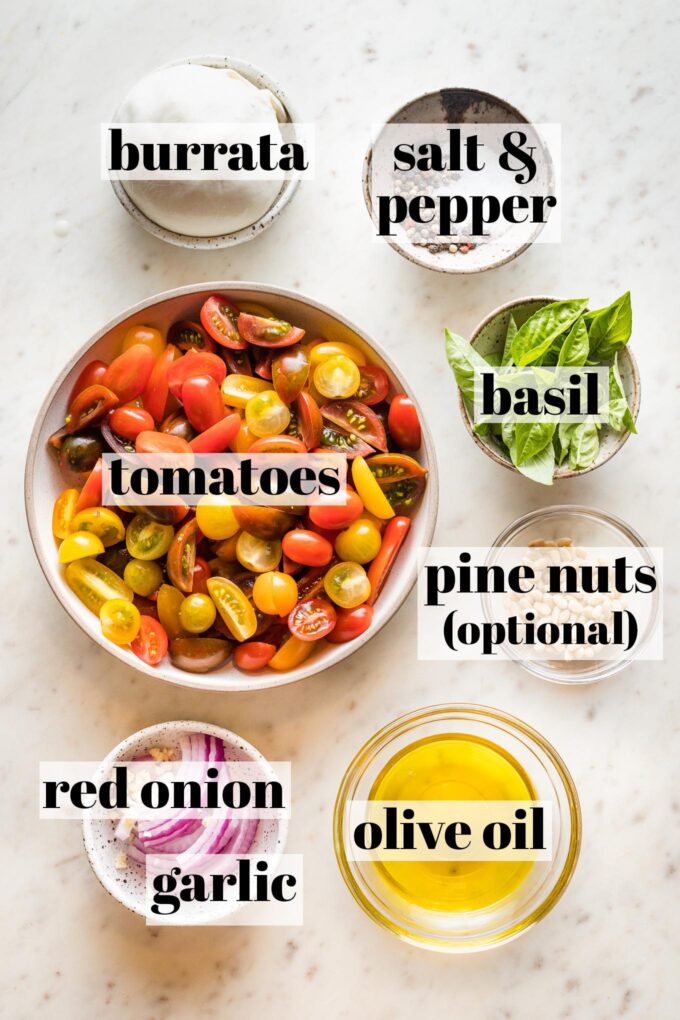 Prep bowls with quartered heirloom tomatoes, red onion, basil, burrata, salt and pepper, garlic, and olive oil.