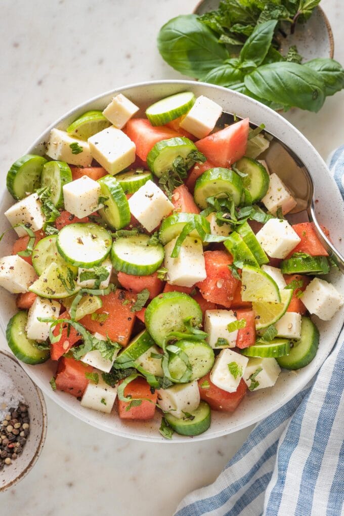 Bowl full of watermelon cucumber salad with feta and mint.