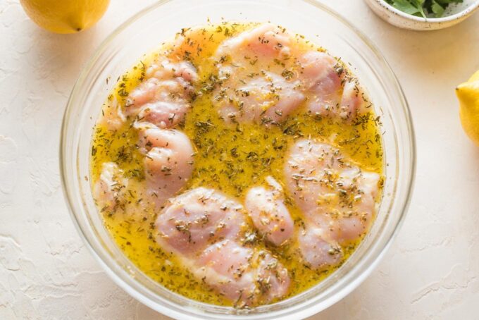 Prep bowl with chicken thighs in a lemon garlic olive oil marinade.