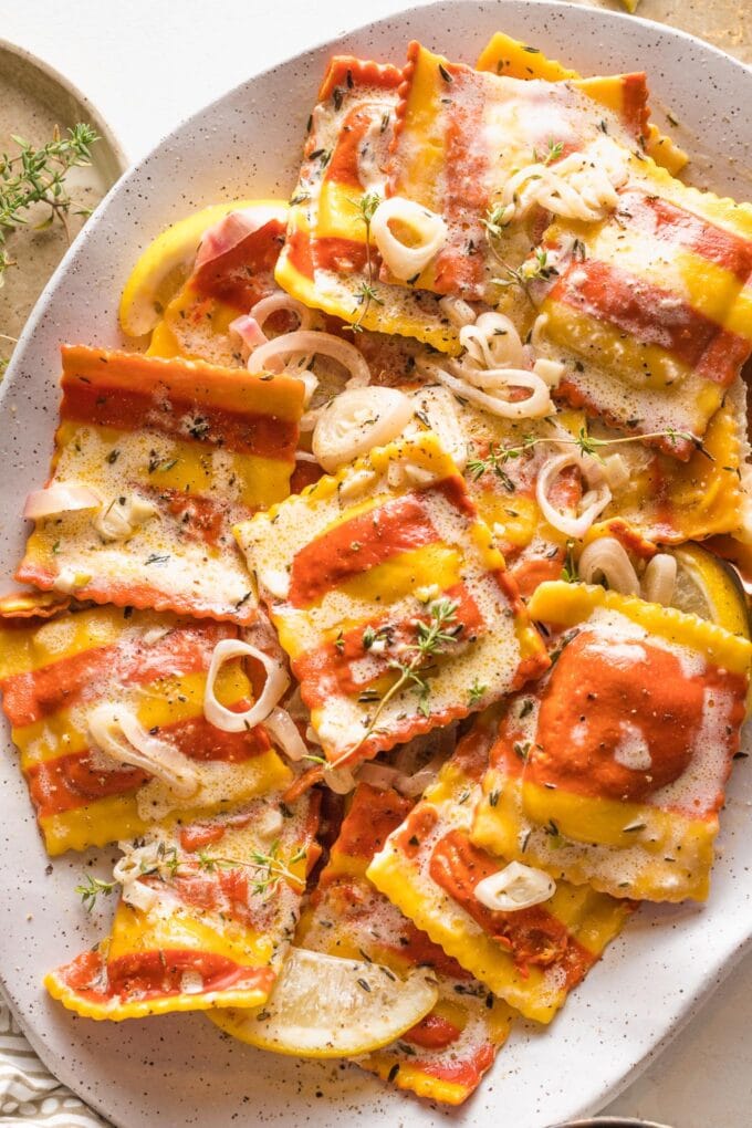 Platter full of lobster ravioli served in a light cream sauce with shallots and thyme.