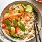 Bowl of Thai green curry with veggies and shrimp served over rice.