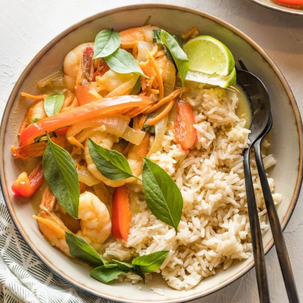Bowl of Thai green curry with veggies and shrimp served over rice.