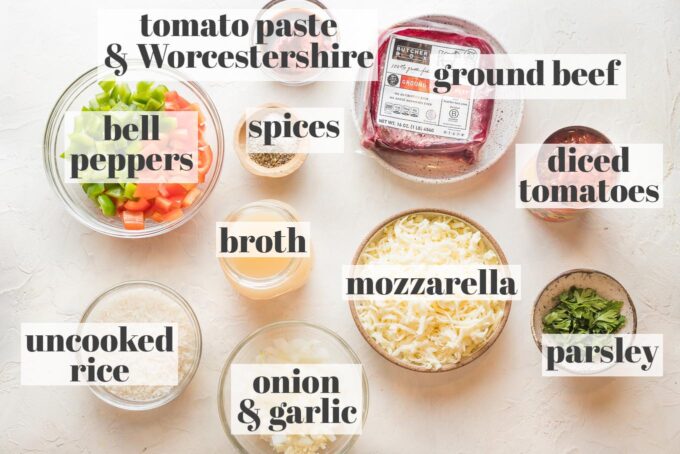 Prep bowls with ground beef, mozzarella, rice, veggies, and seasonings for a stuffed pepper skillet.