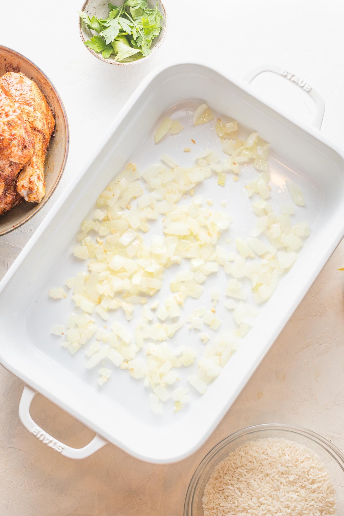 Cooked onions spread in a baking pan.