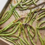 Rimmed sheet pan filled with roasted green beans.