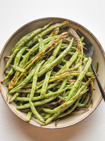 Small serving bowl filled with roasted garlic green beans.