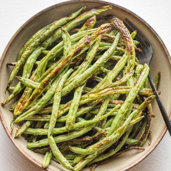 Small serving bowl filled with roasted garlic green beans.