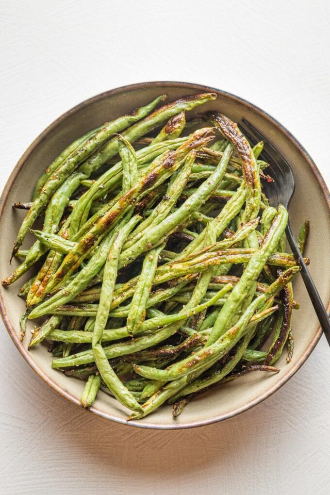 Small serving bowl filled with roasted garlic green beans.