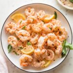 Plate full of cooked red Argentine shrimp served in a garlic lemon butter sauce.