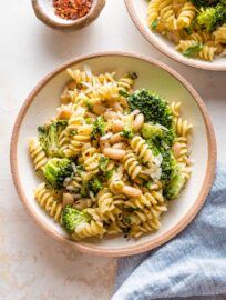 Small pasta bowl with a serving of pasta with white beans and broccoli.