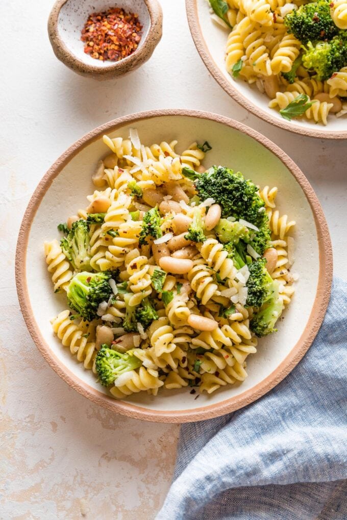 Small pasta bowl with a serving of pasta with white beans and broccoli.