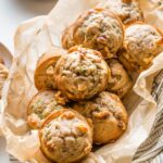 Basket full of banana zucchini muffins with walnuts.