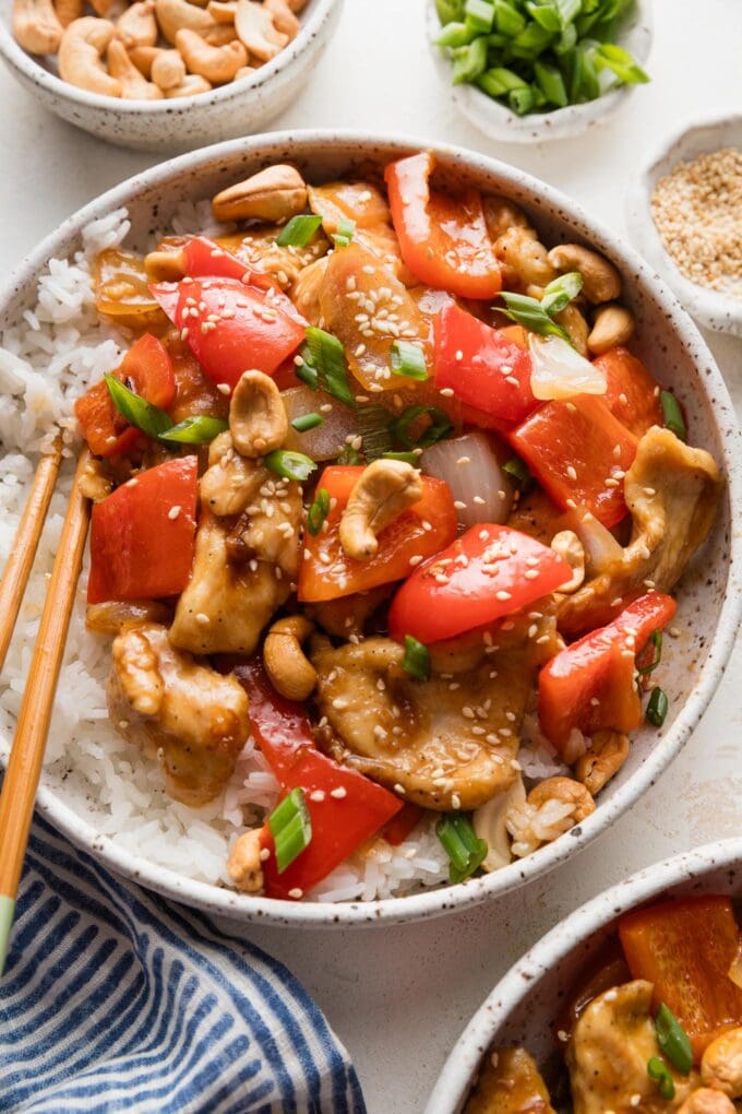 Chicken and bell pepper stir fry served in a low noodle bowl with rice.