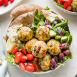 Bowl of Greek chicken meatballs served with lettuce and veggies.